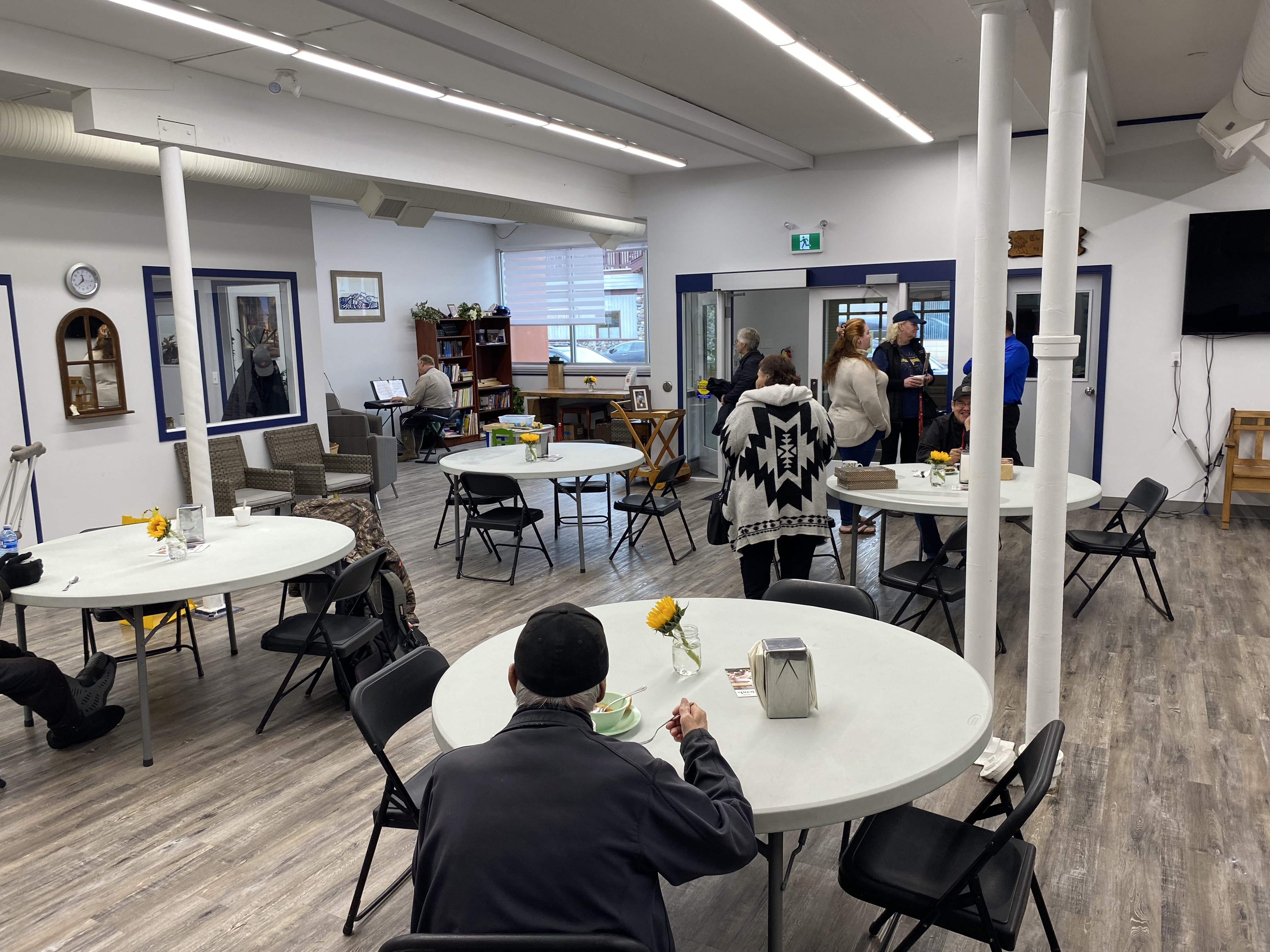 Interior of The Salvation Army Bulkley Valley Ministries community space, with people gathered around tables for fellowship and support activities.