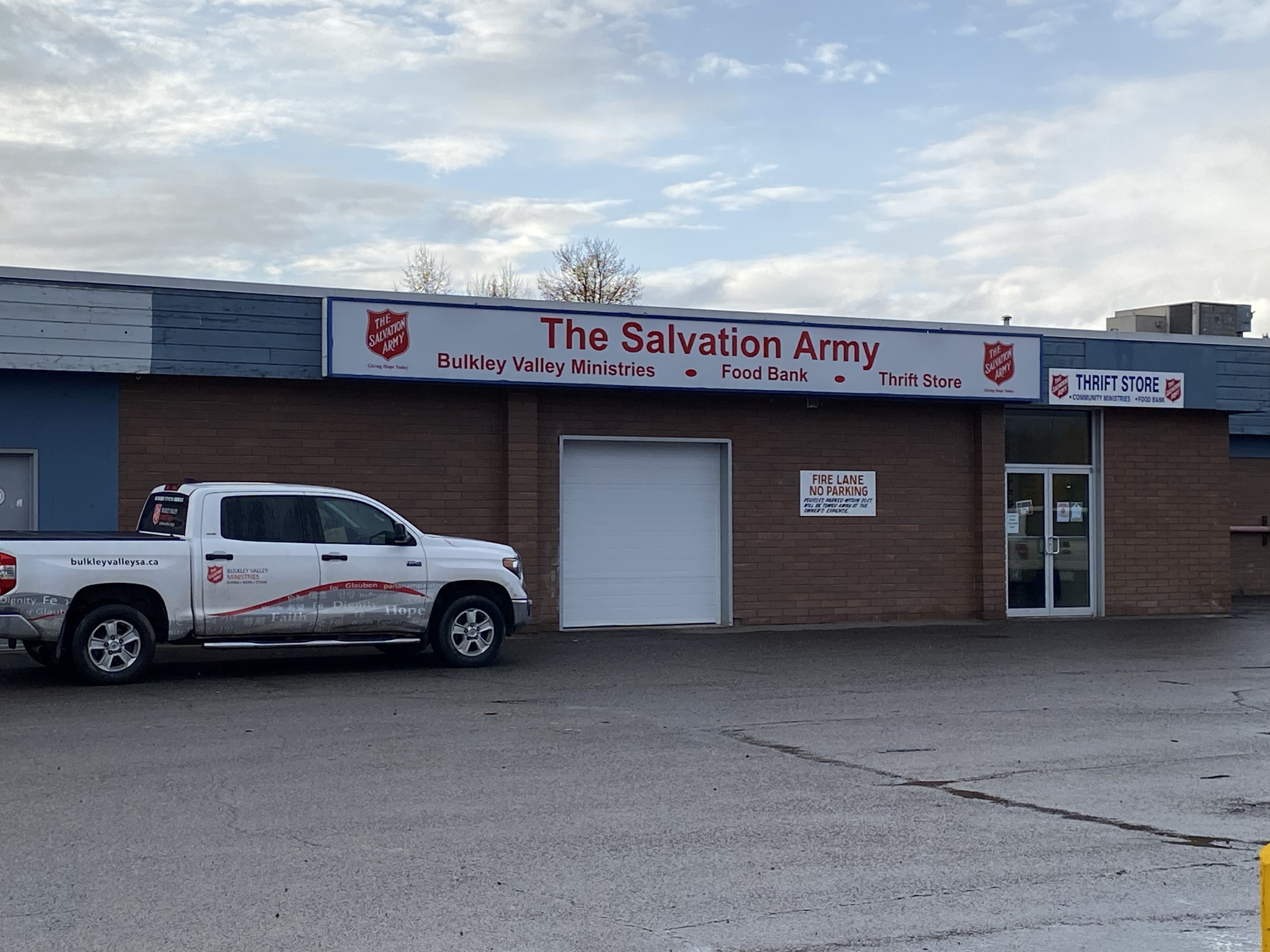 Exterior of The Salvation Army Bulkley Valley Ministries building, with signage visible and a service vehicle parked in front.