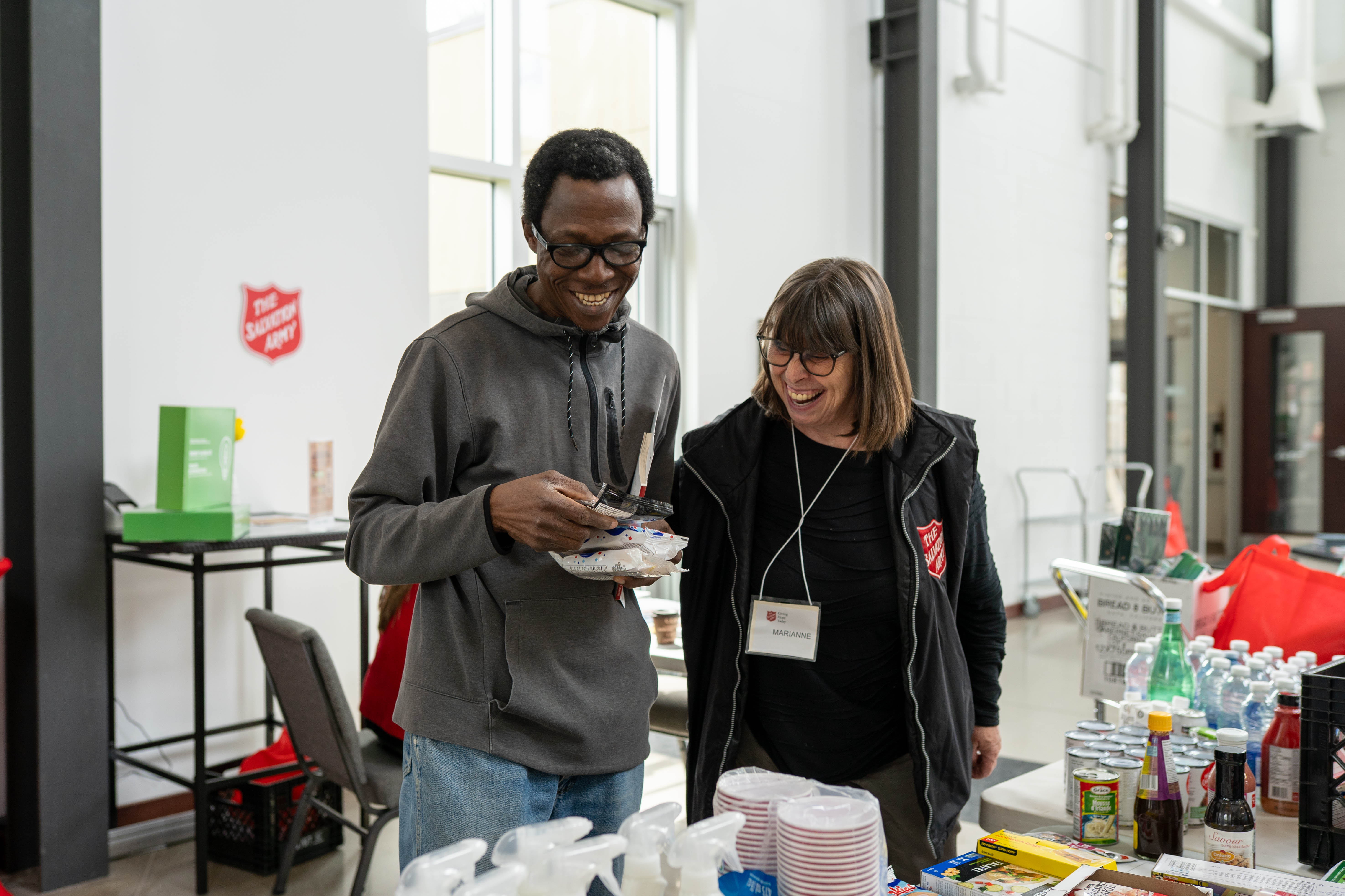 Two people standing at a table organizing donated food items.
