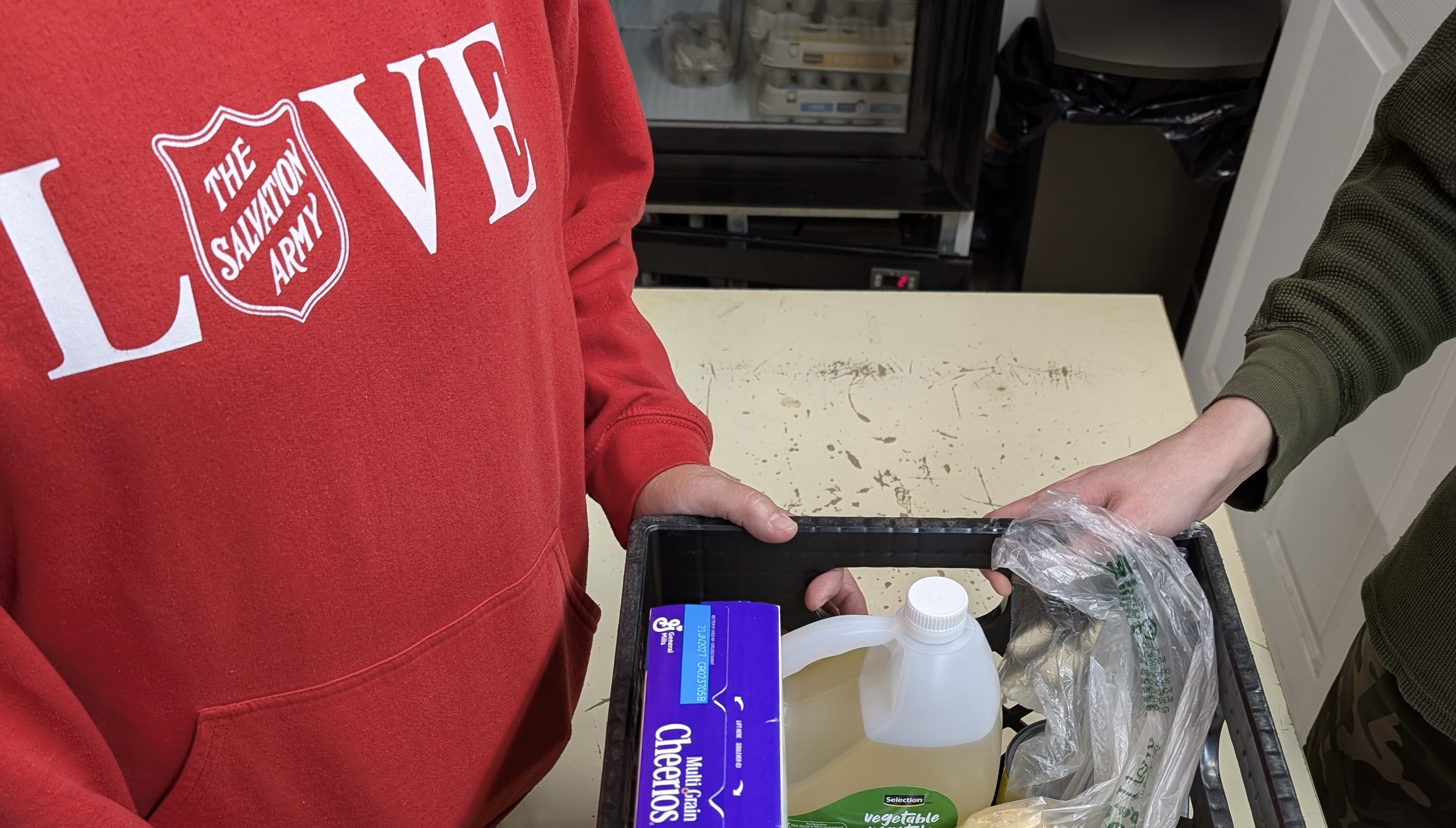 Salvation Army worker provides food hamper to client